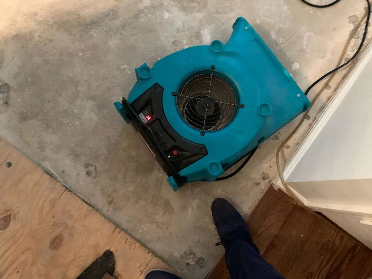 Air mover drying subfloor during Commercial Water Damage Restoration in Greendale